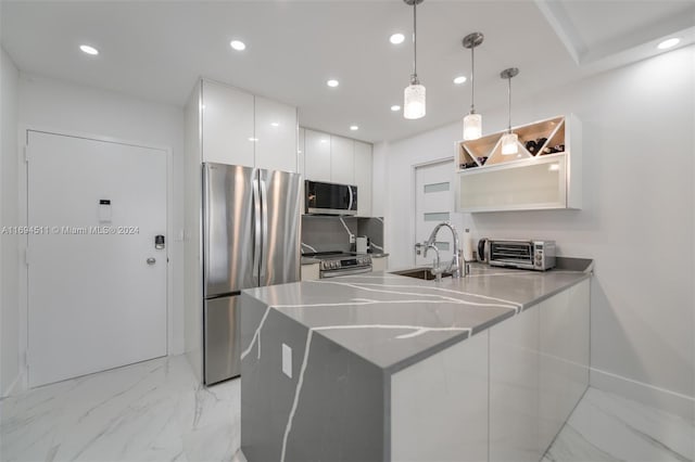 kitchen with pendant lighting, white cabinets, sink, kitchen peninsula, and stainless steel appliances