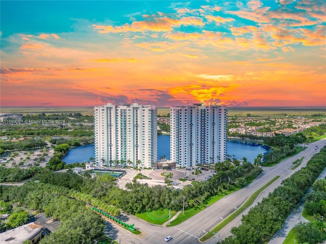 aerial view at dusk featuring a water view