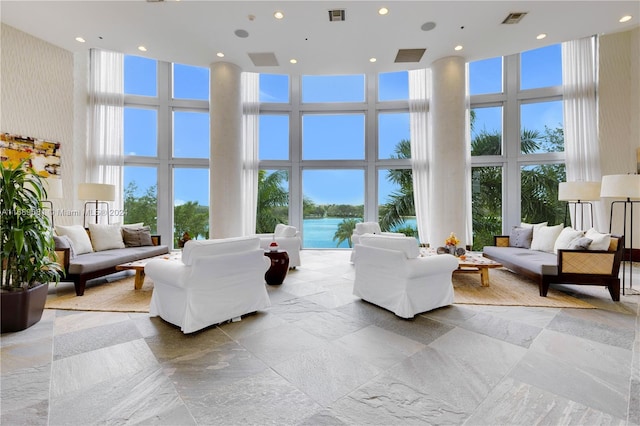 living room featuring expansive windows, a healthy amount of sunlight, and a high ceiling