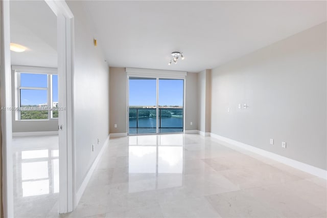 unfurnished room featuring a water view