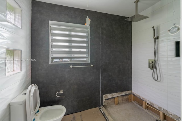 bathroom with toilet, tile walls, and tiled shower