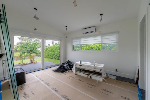 interior space featuring plenty of natural light, an AC wall unit, and lofted ceiling