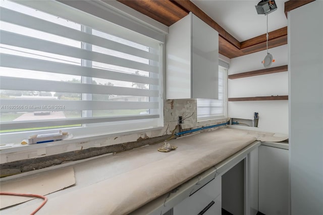 kitchen with white cabinets, pendant lighting, and tasteful backsplash