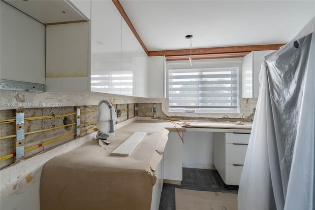 interior space featuring decorative light fixtures, white cabinetry, and tasteful backsplash