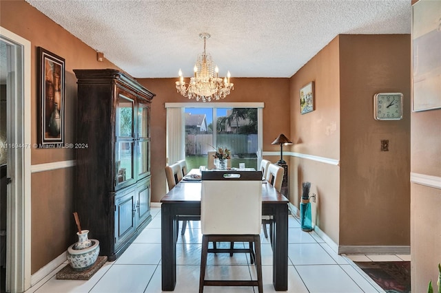 tiled dining space with a chandelier and a textured ceiling