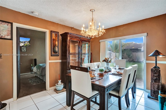 dining area with a notable chandelier, light tile patterned floors, and a textured ceiling