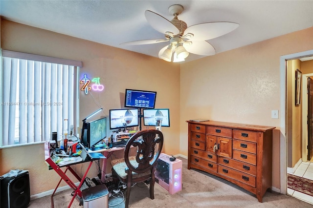 carpeted home office featuring ceiling fan