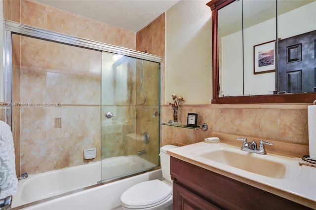 full bathroom with vanity, toilet, combined bath / shower with glass door, and tile walls