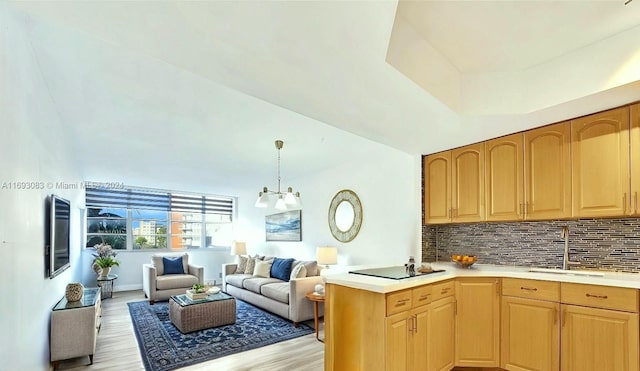 kitchen featuring decorative backsplash, sink, pendant lighting, and light hardwood / wood-style flooring