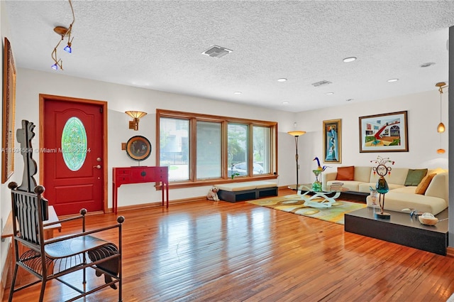 living room featuring hardwood / wood-style flooring, a healthy amount of sunlight, and a textured ceiling