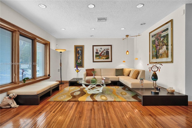 living room with hardwood / wood-style floors and a textured ceiling