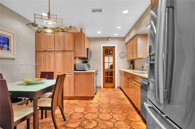 kitchen featuring sink, light tile patterned floors, pendant lighting, and appliances with stainless steel finishes