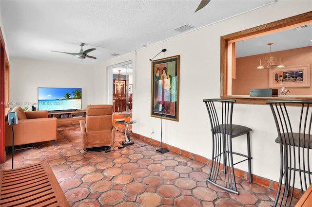 living room with a textured ceiling and ceiling fan