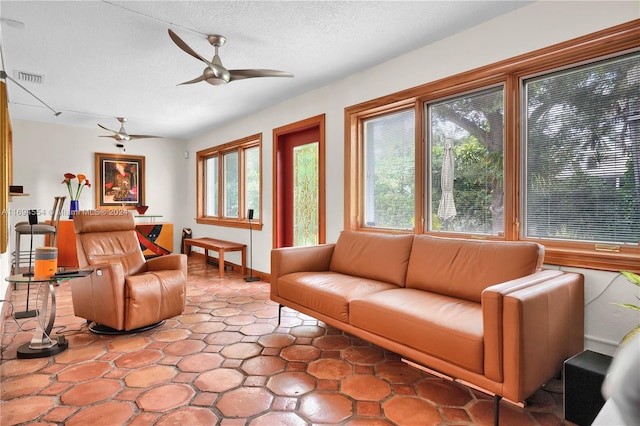 living room with a textured ceiling and ceiling fan