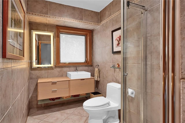 bathroom with tile patterned floors, an enclosed shower, vanity, tile walls, and toilet