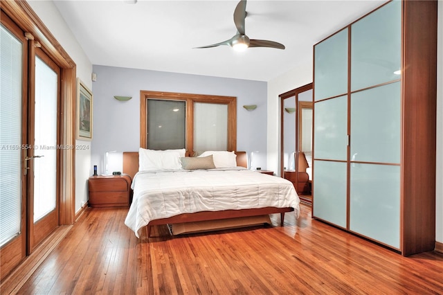 bedroom with ceiling fan, multiple windows, and light hardwood / wood-style flooring