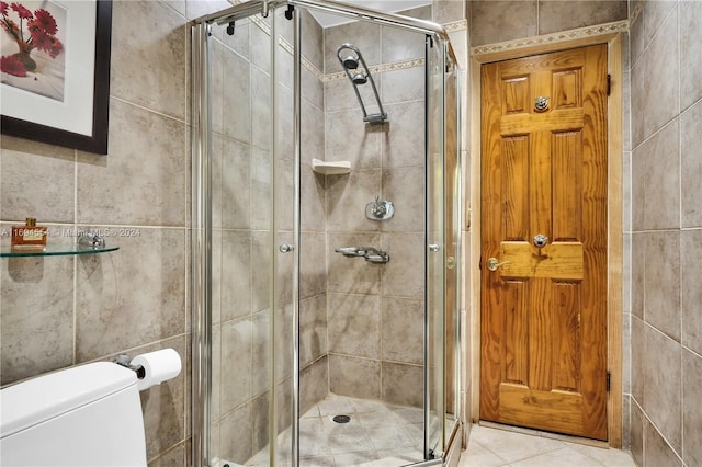 bathroom featuring tile walls, an enclosed shower, and toilet