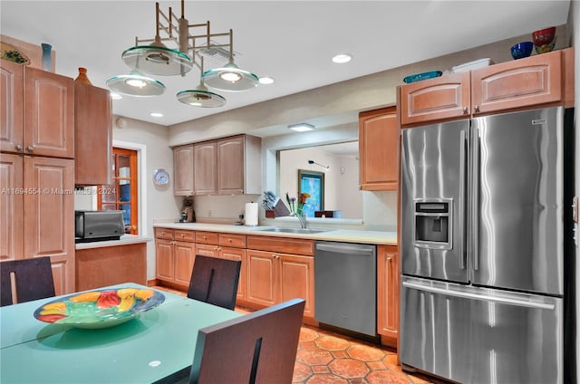 kitchen featuring hanging light fixtures, sink, and appliances with stainless steel finishes