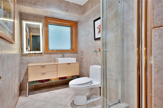 bathroom featuring tile patterned flooring, vanity, toilet, and tile walls