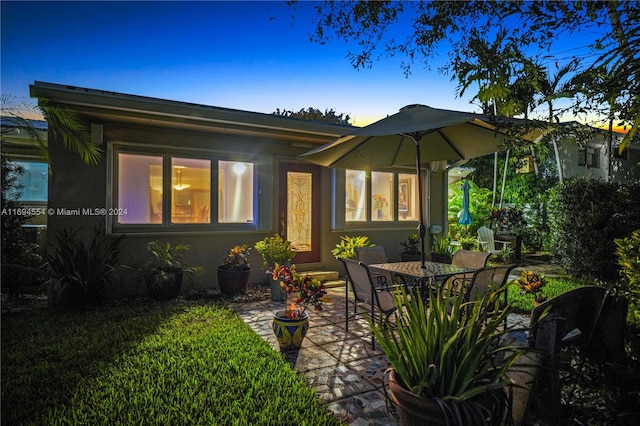 back house at dusk with a patio