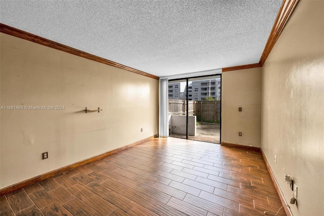 empty room featuring crown molding, hardwood / wood-style floors, and a textured ceiling