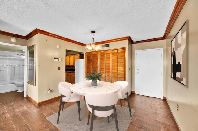 unfurnished room featuring hardwood / wood-style floors, a textured ceiling, and ornamental molding