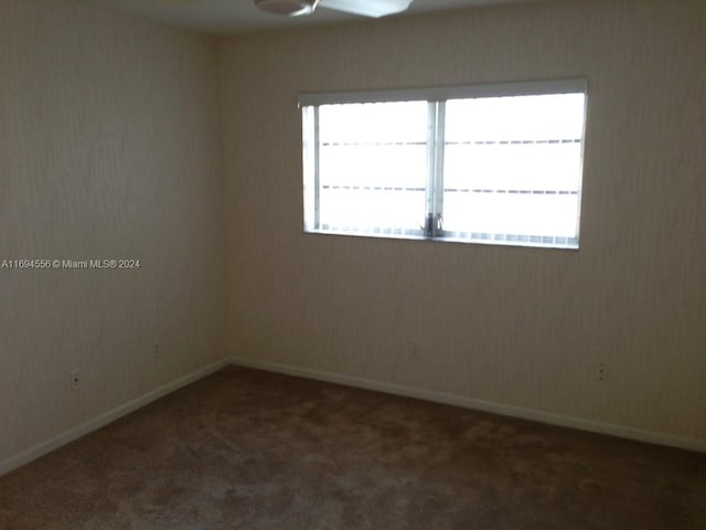 spare room with dark carpet