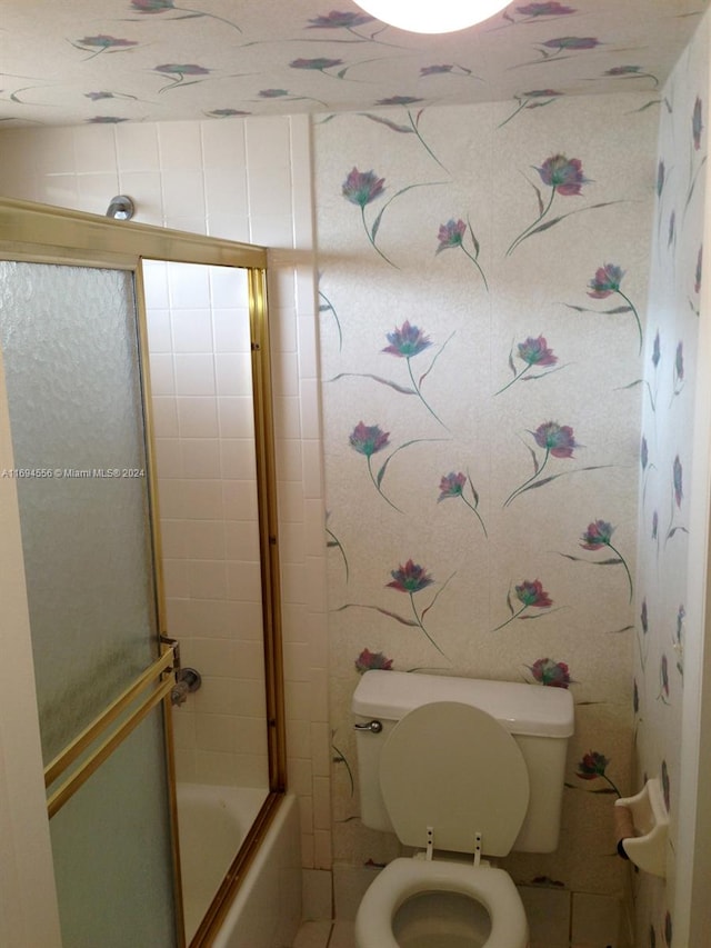 bathroom with enclosed tub / shower combo and toilet