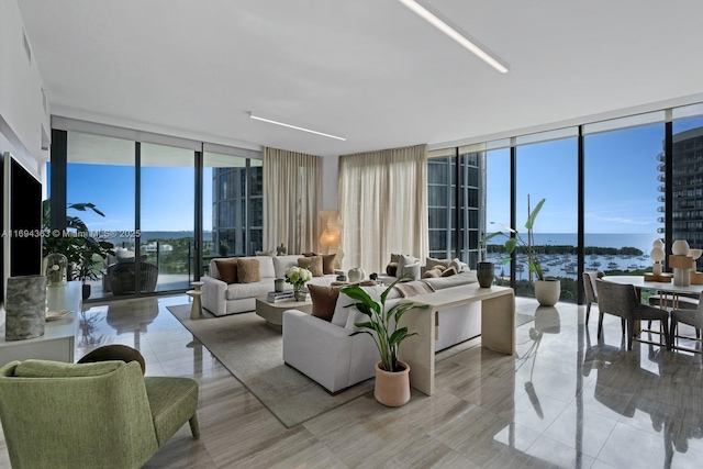 tiled living room featuring a water view and a wall of windows