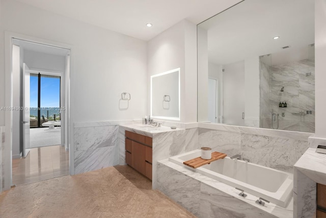 bathroom with vanity and independent shower and bath