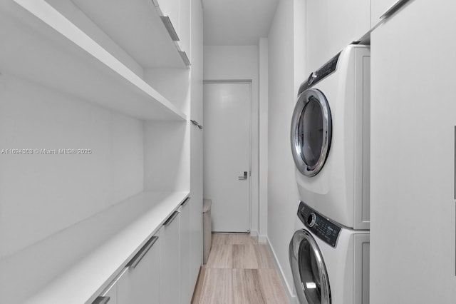 clothes washing area featuring stacked washer and dryer