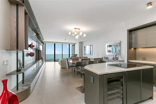 kitchen featuring floor to ceiling windows, a center island, hanging light fixtures, wine cooler, and black electric cooktop