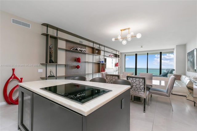 18975 Collins Ave Unit 3402, Sunny Isles Beach, FL 33160 - kitchen featuring black electric cooktop, a chandelier, open shelves, light countertops, and light tile patterned flooring