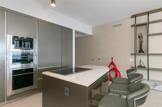 kitchen with stainless steel double oven and black electric cooktop