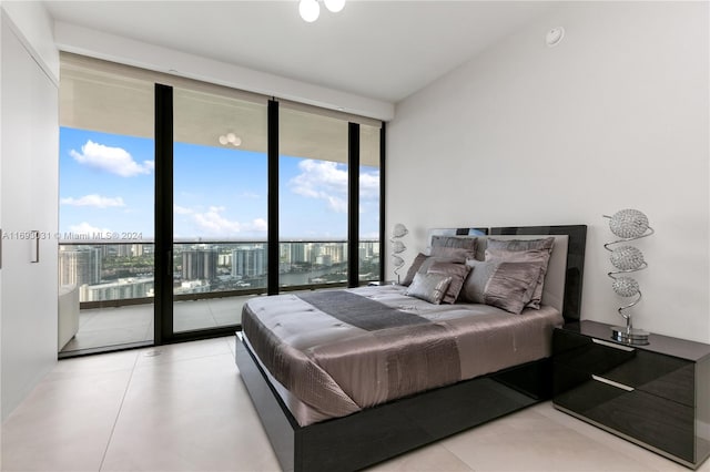 bedroom with a water view, a wall of windows, access to outside, and multiple windows