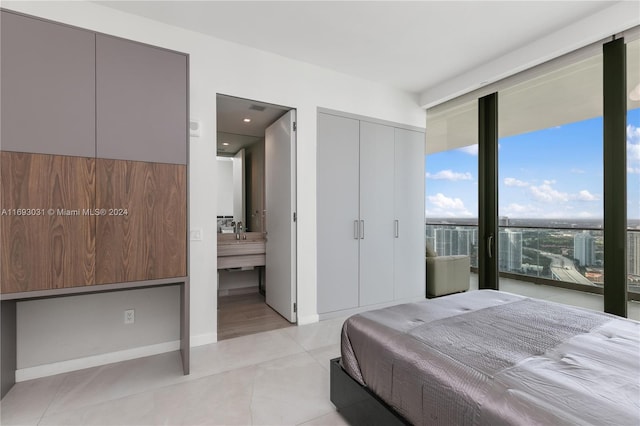 18975 Collins Ave Unit 3402, Sunny Isles Beach, FL 33160 - bedroom featuring expansive windows, light tile patterned floors, baseboards, ensuite bath, and recessed lighting