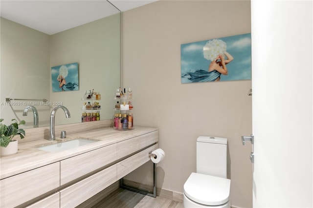 bathroom with hardwood / wood-style flooring, vanity, and toilet