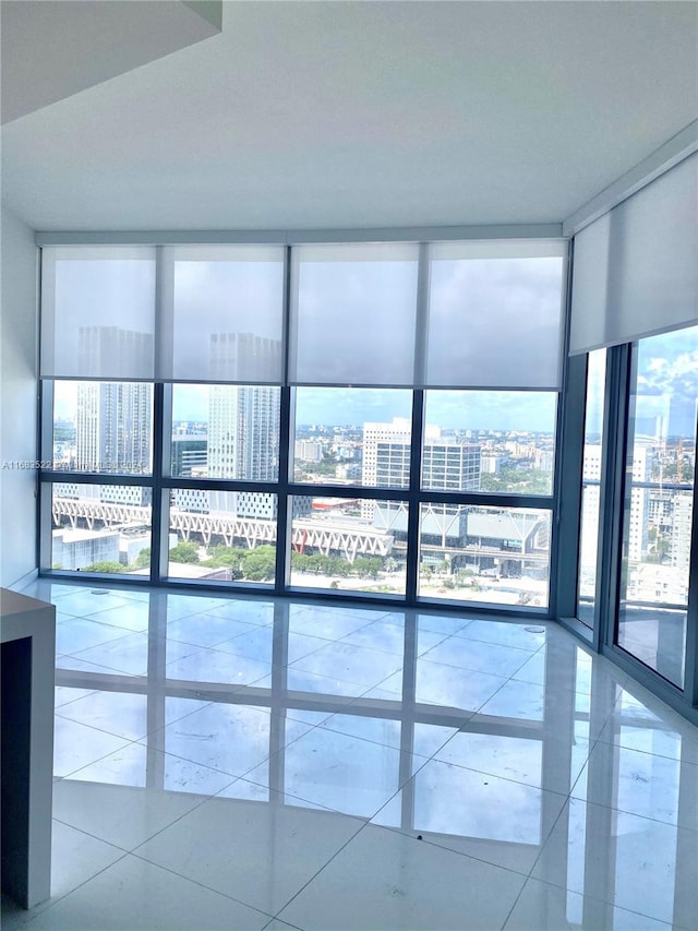 tiled spare room featuring floor to ceiling windows