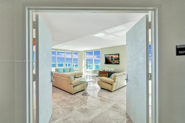 living room featuring a water view and a wall of windows