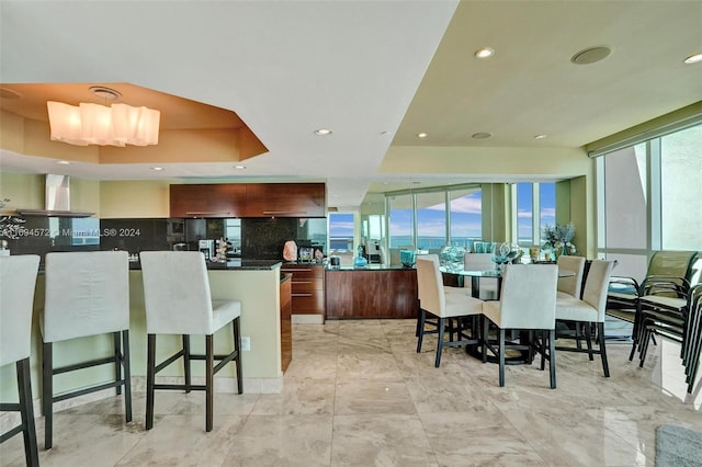 kitchen featuring decorative backsplash, a center island, a kitchen bar, and extractor fan