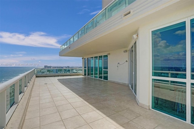 view of patio featuring a water view and a balcony