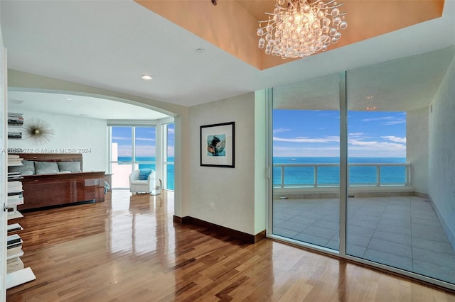 interior space with a chandelier, wood-type flooring, and a water view