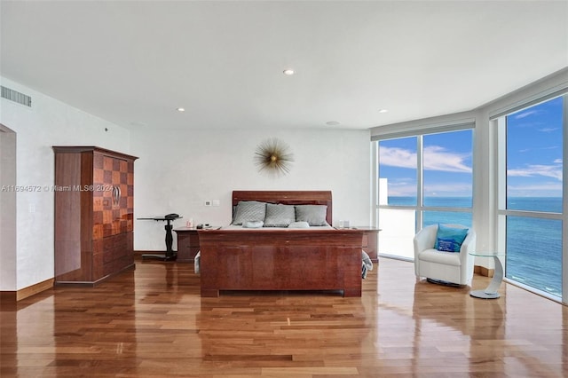 bedroom featuring a water view and wood-type flooring