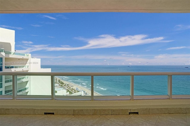 balcony featuring a water view and a beach view