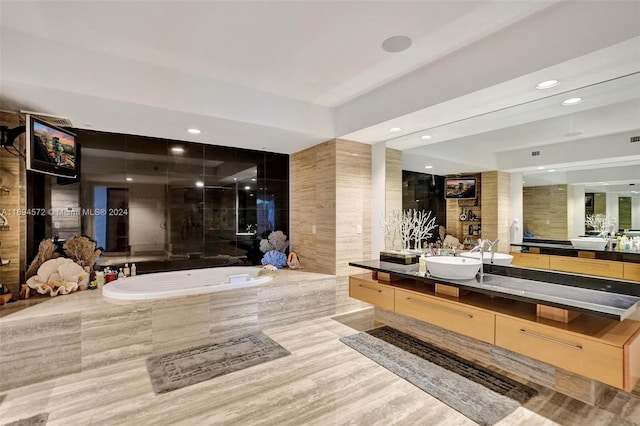 bathroom featuring tiled tub, vanity, and hardwood / wood-style flooring