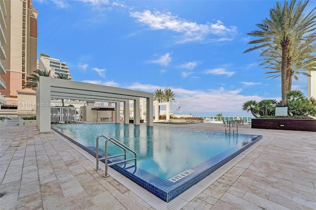 view of pool with a patio area and a water view