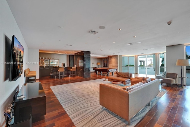 living room featuring bar area, wood-type flooring, expansive windows, and pool table