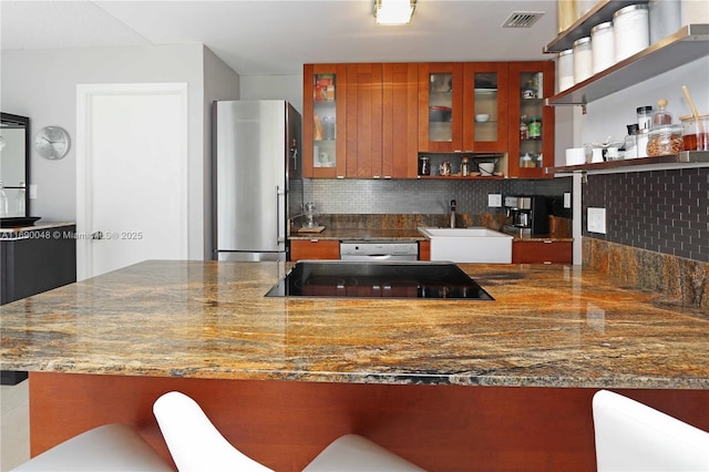 kitchen with kitchen peninsula, appliances with stainless steel finishes, tasteful backsplash, and sink