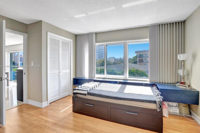 bedroom featuring a closet, a textured ceiling, and light hardwood / wood-style flooring