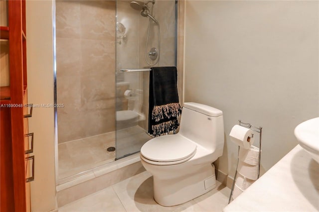 bathroom featuring tile patterned floors, toilet, and a shower with door